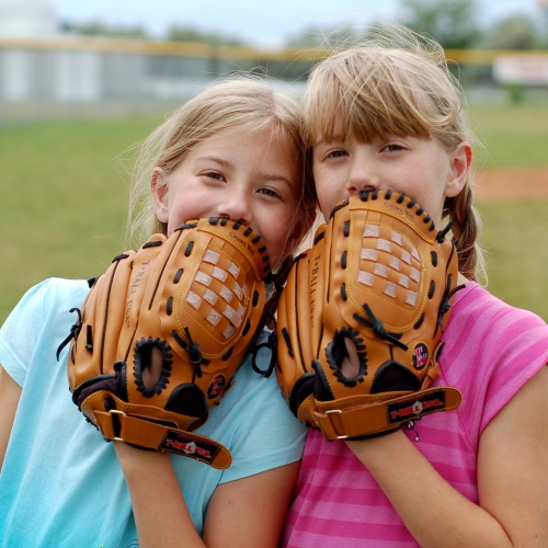 Two twin sisters enjoying their baseball game.