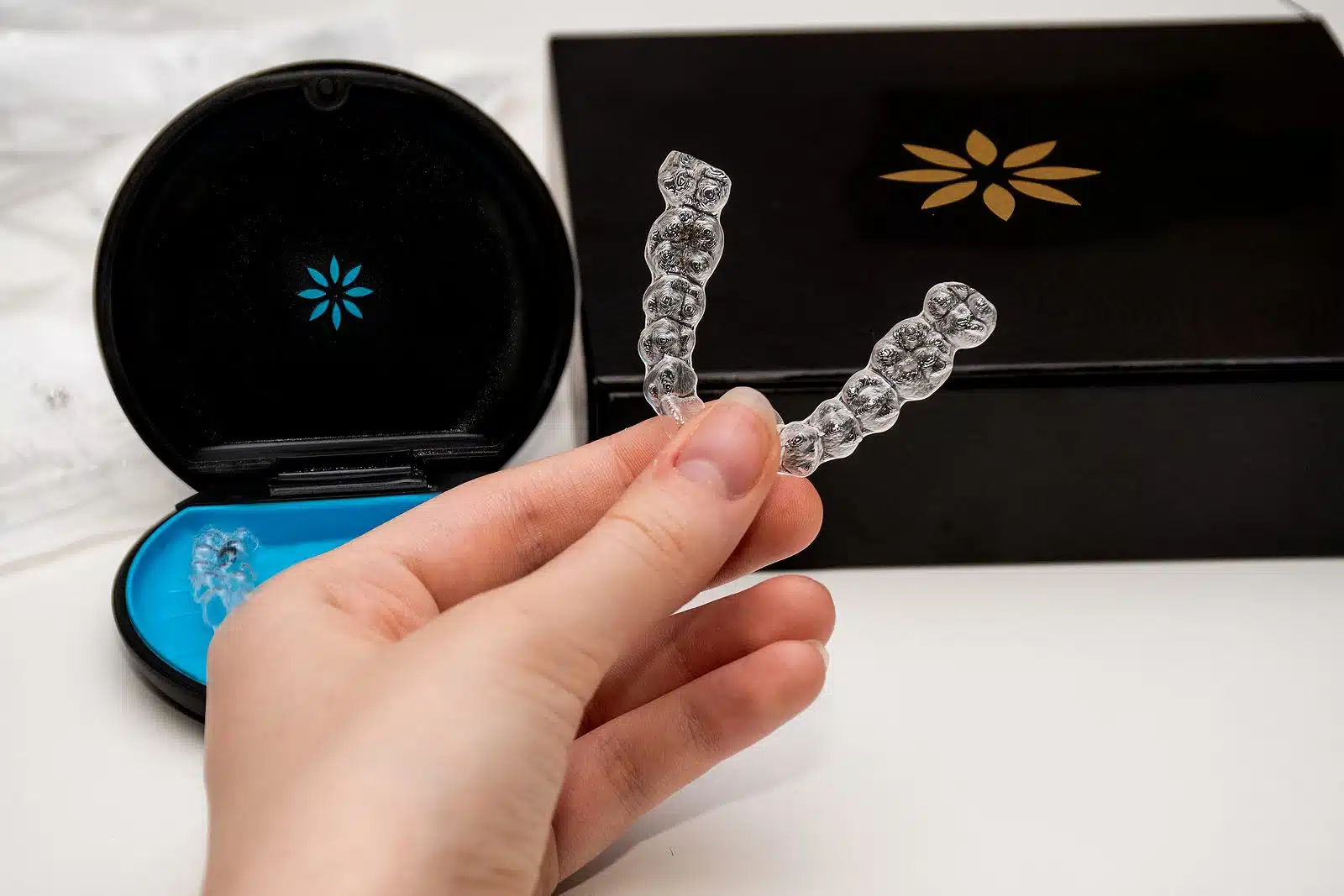 Hand holding clear aligners in a protective case showing modern clear aligners for orthodontic care