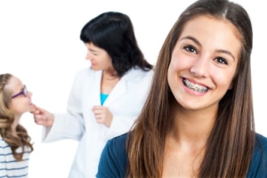 Teen smiling with braces during an orthodontic exam showing braces care for kids and teens