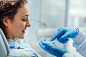 Orthodontist explaining dental model to patient during Invisalign vs clear aligners consultation