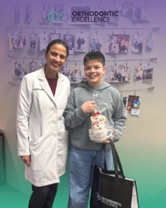 Dr. Megha Anand at Orthodontic Excellence posing with a smiling young patient